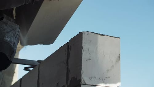 Construction Worker Building Wall with Concrete Blocks