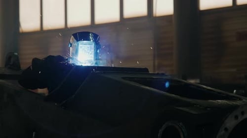 Factory Worker Welding Metal Details with Blow Torch