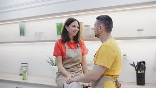 Smiling Couple Holding Hands in Bright Kitchen