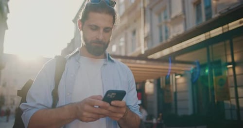 Young Handsome Tourist Walking on Urban Sunny Street at Summertime Positive Guy Holding Using