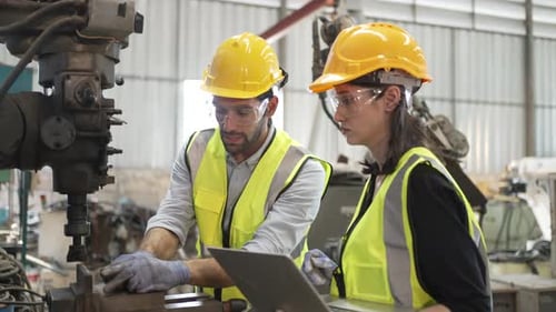 Blue collar workers at machine shop with coring machine.