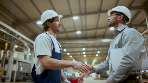 Engineer Shaking Hands with Mechanic, Instructing Him at Work in Factory