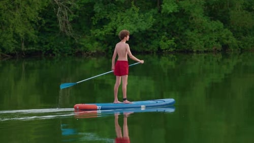 Teenager with Paddle on a Sup Floats on a Picturesque Lake Active Lifestyle Concept