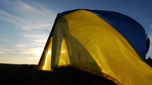Ukrainian Flag Waving in the Wind at Sunset