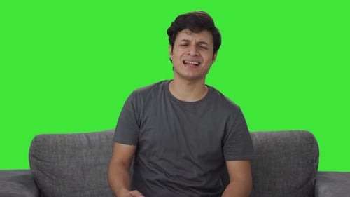 Frustrated Indian man loses a match in video game Green screen