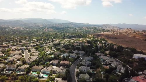 Aerial establishing shot of Hidden Hills Neighborhood with luxury homes and houses. Main street with