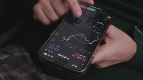 Close Up Smartphone with Stock Market Graph on Touch Screen with Hands Scrolling Checking Stock