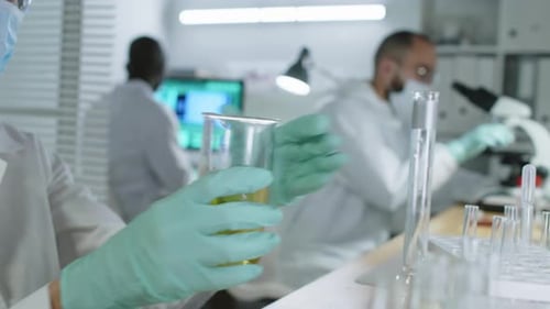 Scientist Working with Yellow Liquid in a Lab