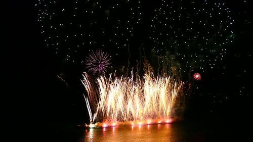 Brilliant Fireworks Exploding over Water at Night