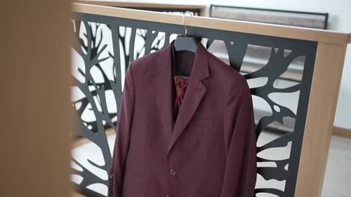 Burgundy Suit Hanging in Elegant Bedroom Setting