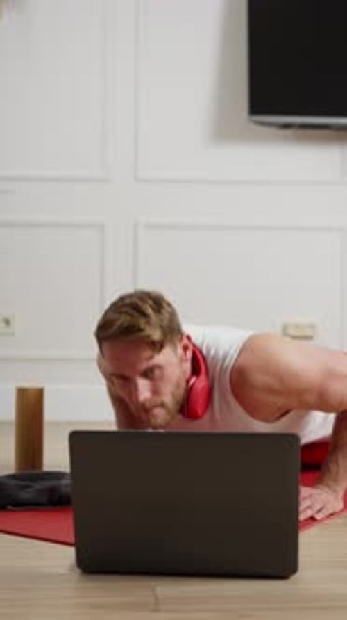 Vídeo vertical: Hombre rubio feliz y seguro de sí mismo con barba de complexión atlética en camiseta blanca haciendo flexiones