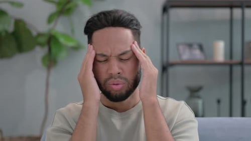 Man Massaging Temples Suffering from Headache