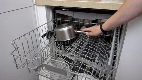 Loading dirty dishes into a modern dishwasher