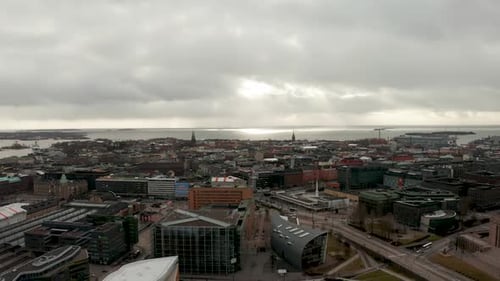 Aerial shot a nordic city with a cloudy sky, in a cold evening, with the sea in the background