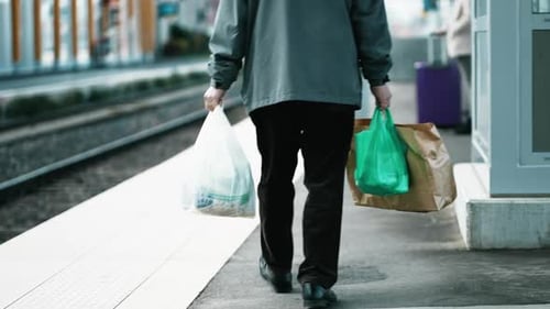 Caballero mayor que lleva comida en la estación de tren: viaje regular