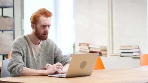 Frustrated Man Working on Laptop in Office