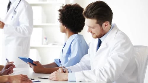 Diverse medical interns listen attentively to mentor's lecture in modern hospital