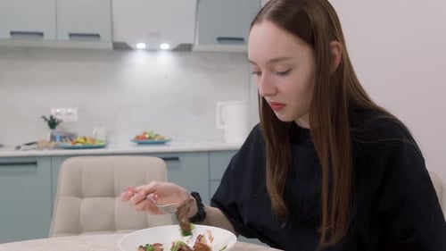 Teenage Girl Eating Salad in Modern Kitchen