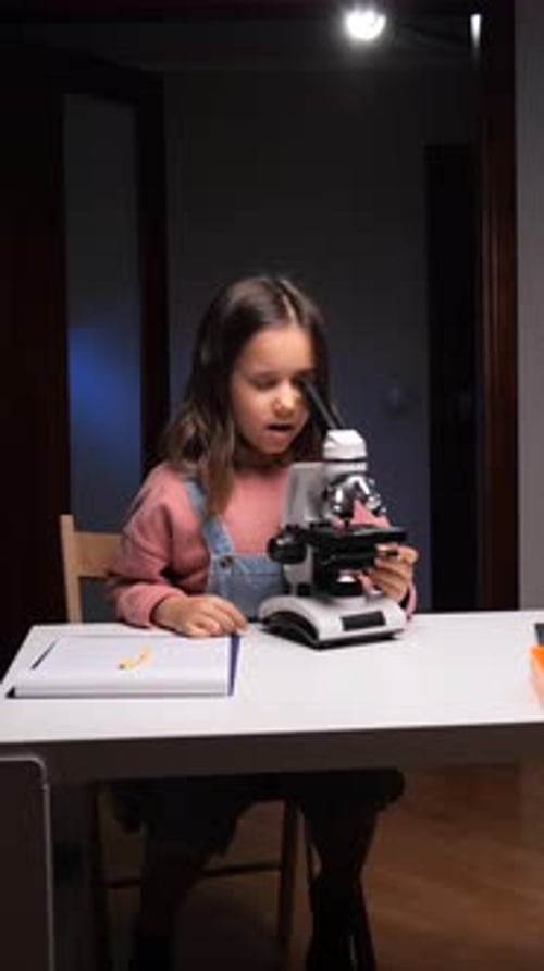Vídeo vertical: Niña que explora el micromundo y descubre la ciencia a través de la investigación con microscopios