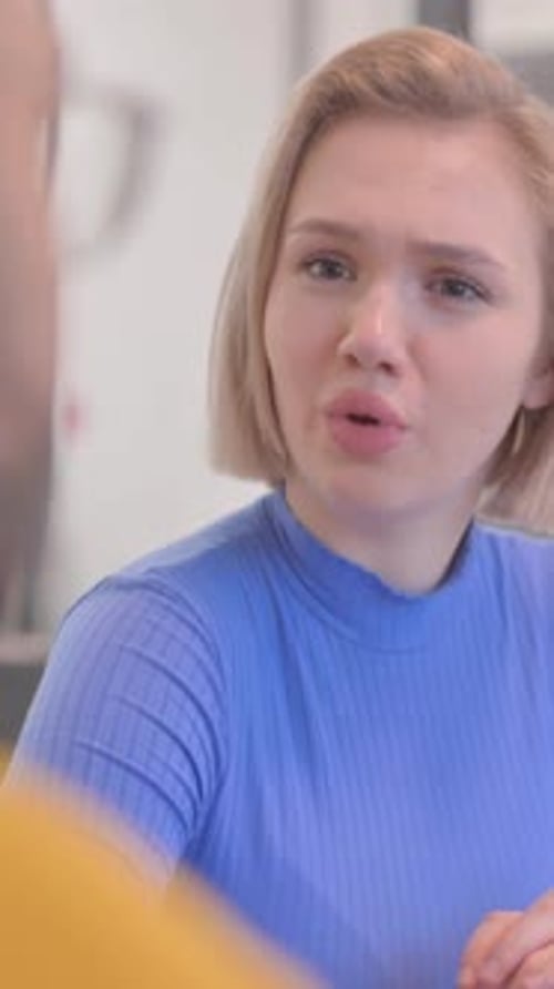 Close up of Blonde Woman Talking with Creative Teammate, vertical video