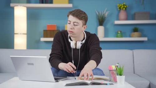 Young Adult Studying with Laptop and Textbook