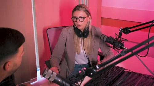 Female podcaster making podcast with young man from her studio.