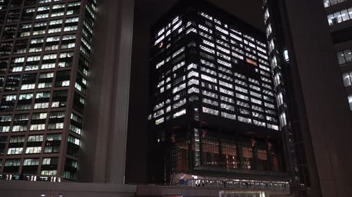 Tokyo Monorail Transits Running On The Railway Station Between High Rise Buildings In Japan At Night