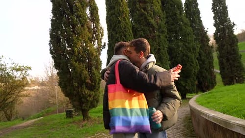 Young caucasian gay couple showing affection in a park