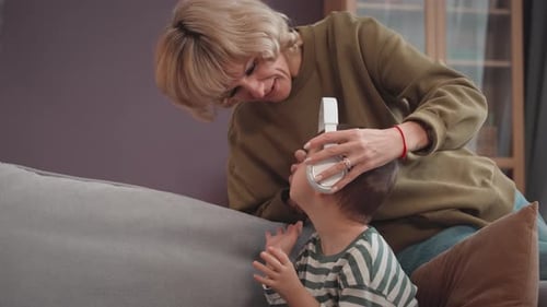 Woman Puts Headphones on Happy Child in Home
