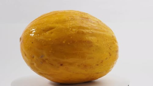 Frische Melone rotiert auf weißem Hintergrund.