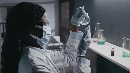 Scientist Examining Liquid in Laboratory Beaker