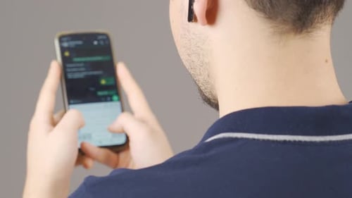 Hombre enviando mensajes de texto por teléfono.