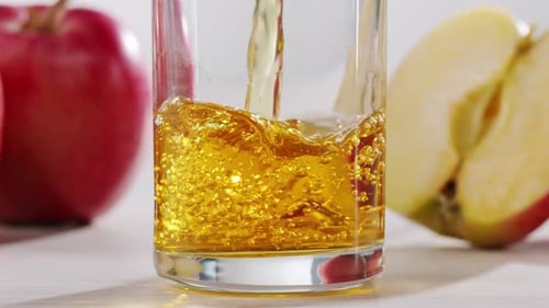 Apple Juice Pouring into Glass Close Up