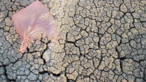 Una bolsa de plástico vuela en tierra seca: desastre ambiental