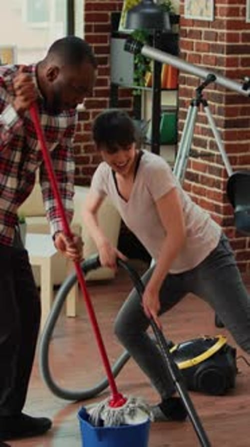 Couple Cleaning Home While Singing and Dancing