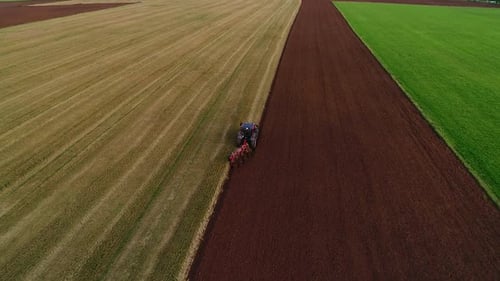 Agroculture field ploughing with four furrow reversible plough aerial wide view
