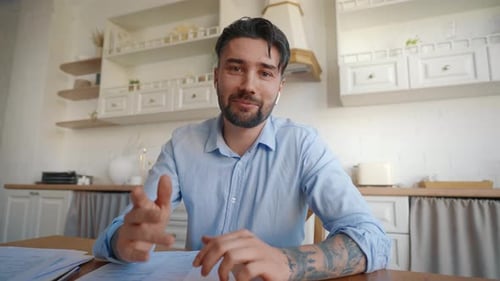 Smiling Man Explains on a Video Call from Kitchen