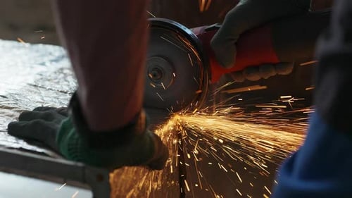 Découpe de matériaux de construction à l'aide d'une meuleuse d'angle et d'étincelles volantes