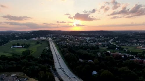 Vue aérienne descendante d'un magnifique coucher de soleil d'été au-dessus d'une autoroute très fréquentée aux États-Unis, étendue des banlieues