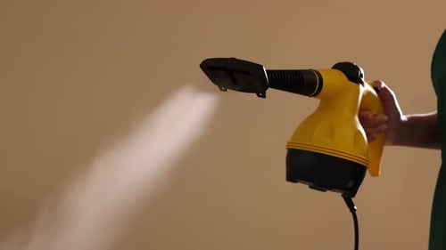 Woman Using Handheld Steam Cleaner in Home