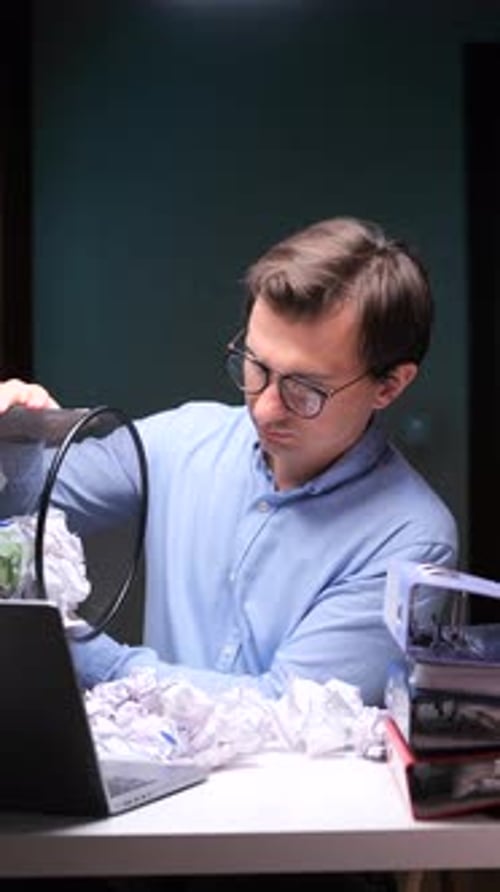 Vertical Video Frustrated Office Worker Emptying Wastebasket on Laptop Keyboard