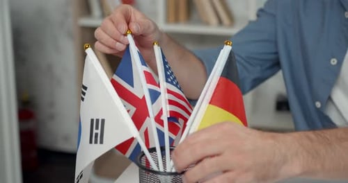Hombre profesor de idiomas que elige entre banderas de diferentes países