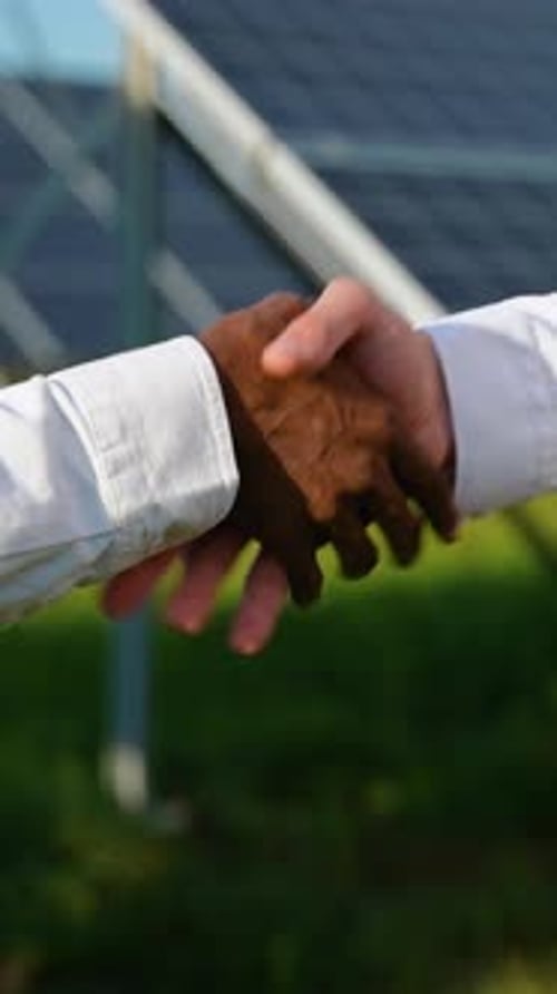 Diverse Businessmen Shaking Hands at Solar Panel Farm