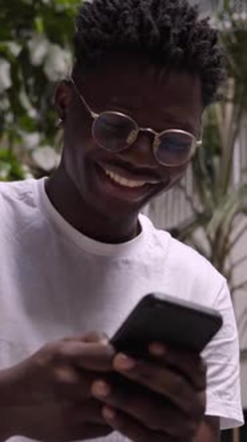 Vertical Video Happy Black Man Using Cell Phone on Break From Work Cheerful Millennial Connecting