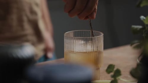 Young Male stirring fresh mixed cocktail in a drinking glas 4K Slow Motion Close Up