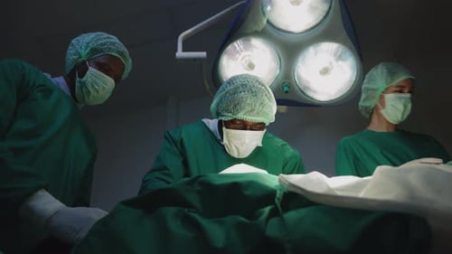 nurse handing a surgical instrument to the surgeon in operating room.