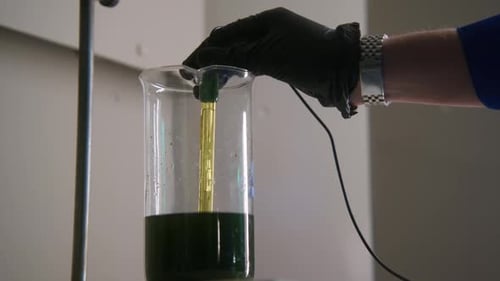 Scientist measures liquid in beaker during lab work