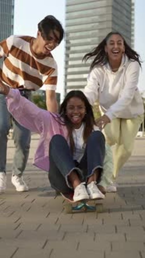 African American Girl with Teenage Friends Have Fun Together on Skateboard in the City