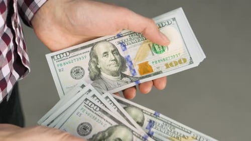 Hands Counting Stack of One Hundred Dollar Bills