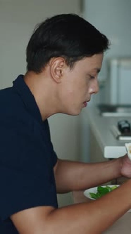 Adult Man Eating Salad at Kitchen Table